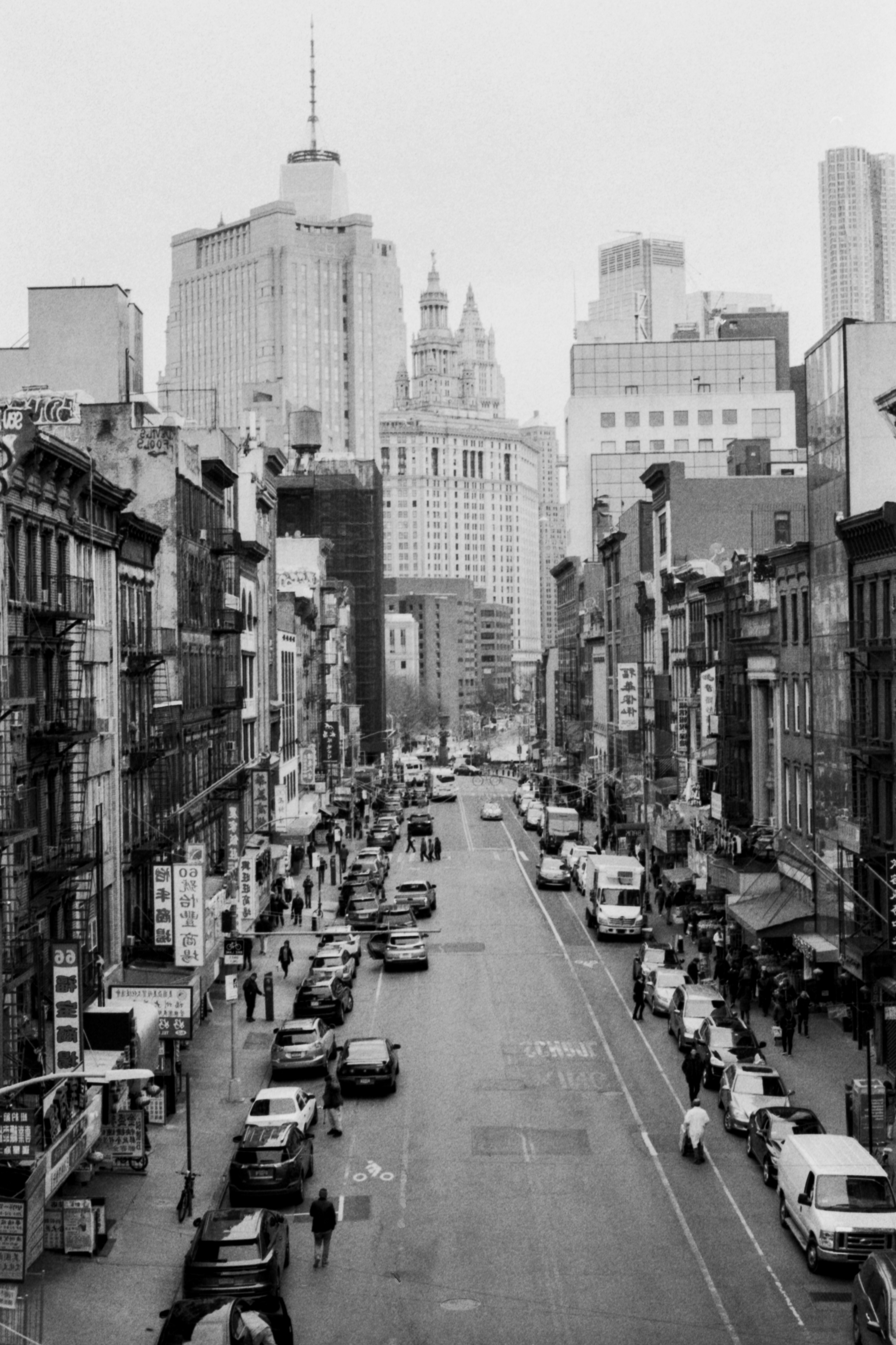 grayscale photo of street across buildings